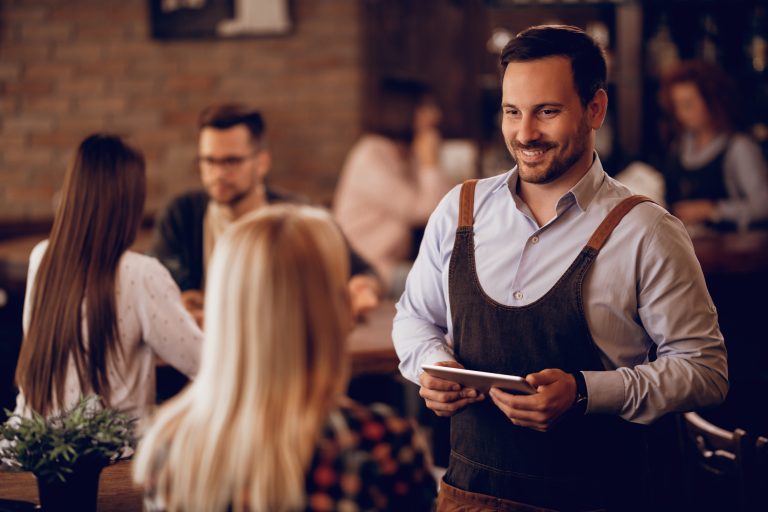 Smiling restaurant owner greeting new customers